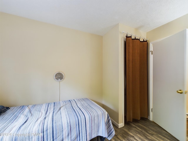 unfurnished bedroom featuring a textured ceiling and wood finished floors