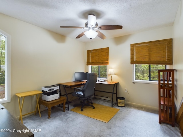 carpeted office featuring a textured ceiling, a ceiling fan, and baseboards