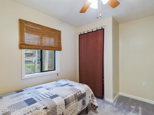 carpeted bedroom featuring ceiling fan and baseboards