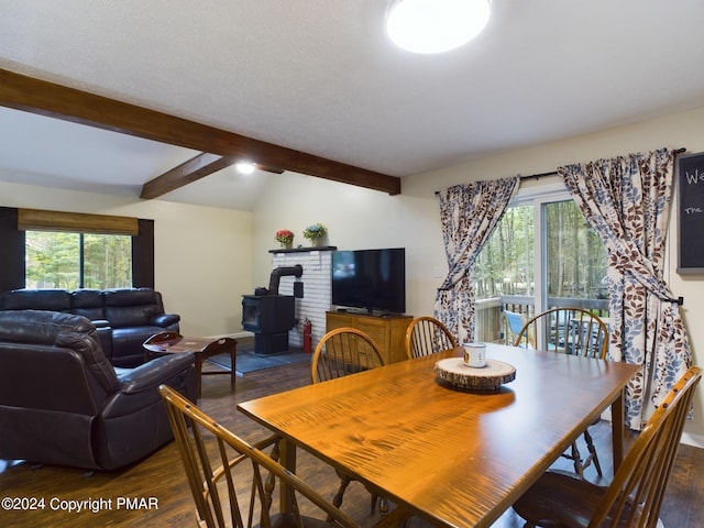 dining area featuring dark wood-type flooring, a wood stove, and vaulted ceiling with beams