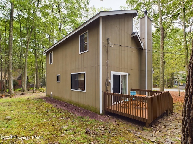 rear view of house with a deck and a chimney