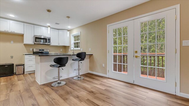 4580 Briarcliff Ter, Tobyhanna, PA 18466 - kitchen with appliances with stainless steel finishes, white cabinets, light wood-style flooring, french doors, and recessed lighting