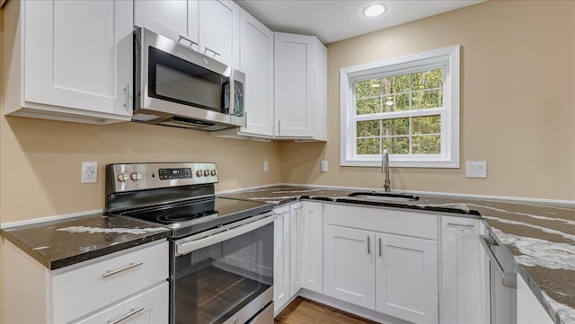4580 Briarcliff Ter, Tobyhanna, PA 18466 - kitchen with stainless steel appliances, white cabinets, dark stone counters, and recessed lighting