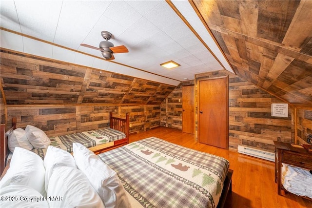 bedroom with lofted ceiling, wooden walls, and wood-type flooring