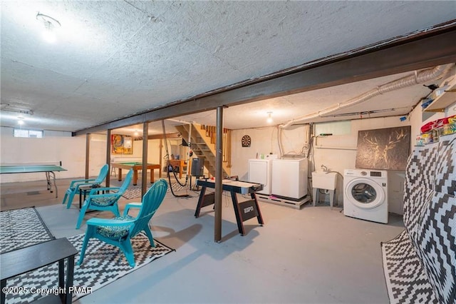 recreation room featuring sink, independent washer and dryer, and concrete floors