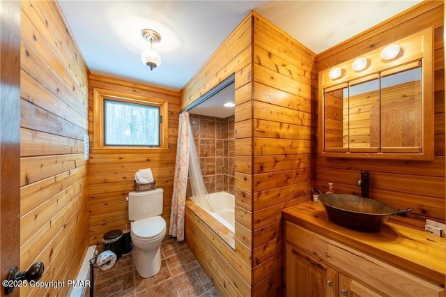 full bathroom featuring wooden walls, vanity, toilet, and shower / bath combo with shower curtain