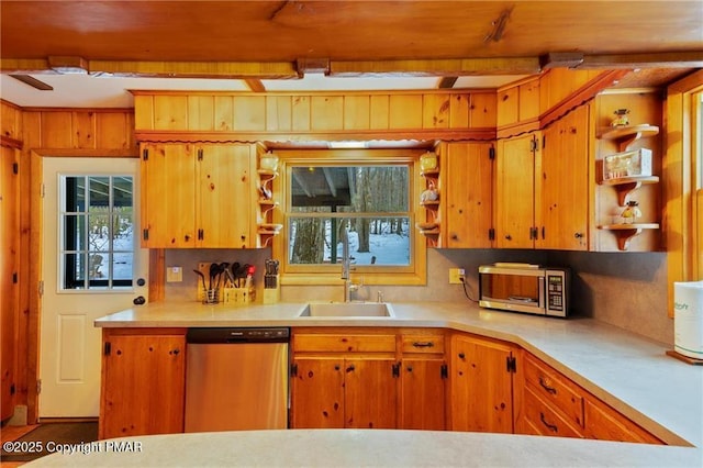 kitchen with sink, appliances with stainless steel finishes, and beamed ceiling