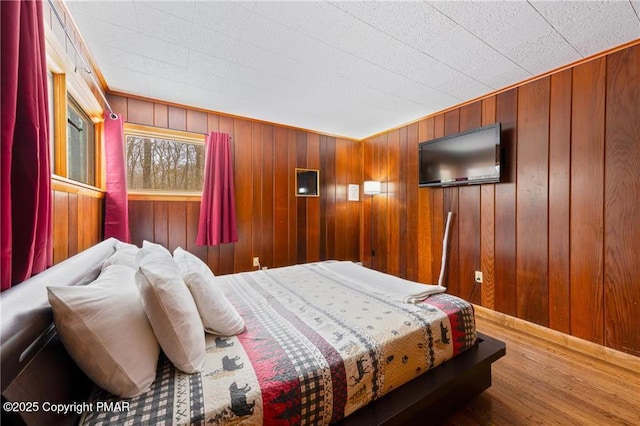 bedroom with wooden walls and wood-type flooring