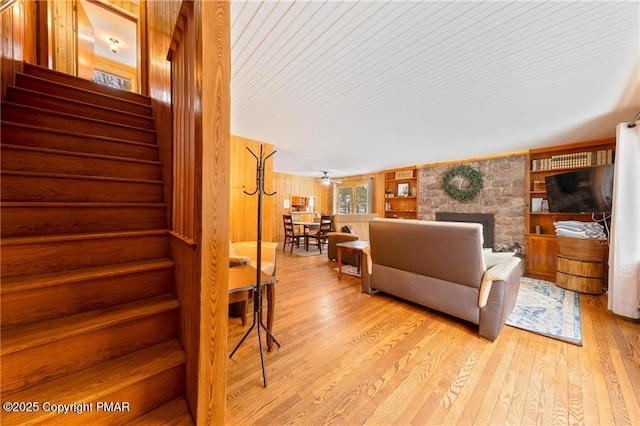 living room featuring light hardwood / wood-style flooring and wood walls