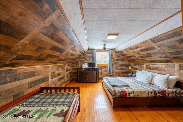 bedroom with wooden ceiling, light wood-type flooring, wood walls, and lofted ceiling