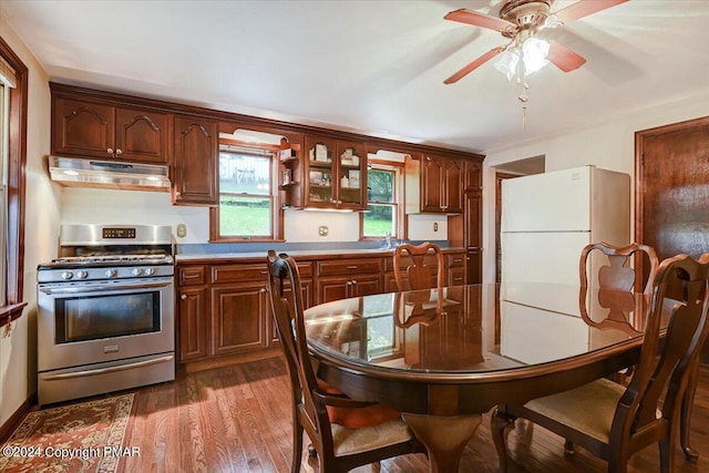 7714 Cherry Valley Rd, Delaware Water Gap, PA 18327 - kitchen with dark wood-style floors, light countertops, freestanding refrigerator, stainless steel range with gas stovetop, and under cabinet range hood