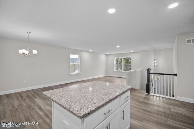 kitchen featuring a healthy amount of sunlight, white cabinets, and wood finished floors