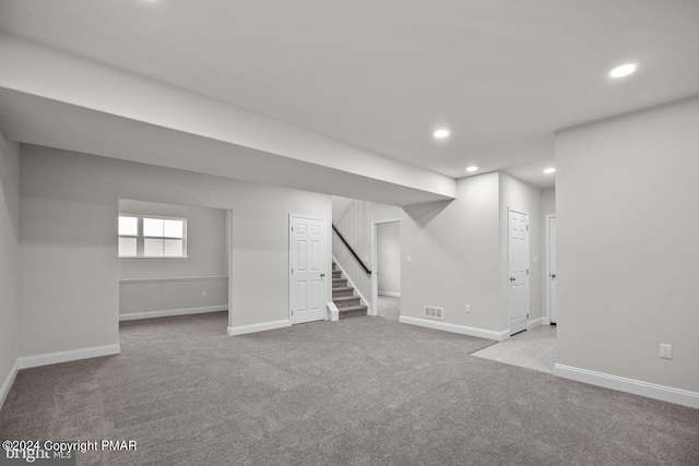 below grade area with recessed lighting, visible vents, baseboards, and stairs