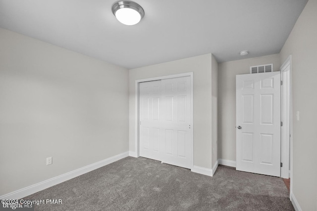 unfurnished bedroom with carpet, a closet, visible vents, and baseboards