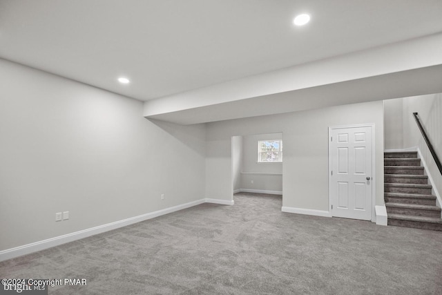 basement featuring carpet floors, baseboards, stairway, and recessed lighting