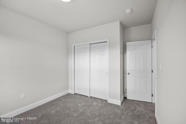 unfurnished bedroom with carpet, baseboards, and a closet