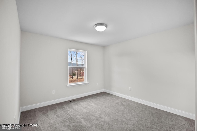 unfurnished room with carpet flooring, visible vents, and baseboards