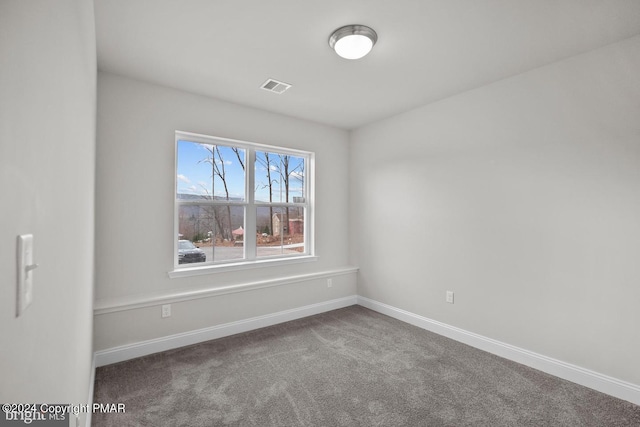 empty room featuring carpet floors, visible vents, and baseboards