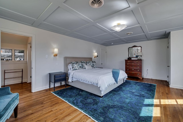 bedroom with wood finished floors, visible vents, and coffered ceiling