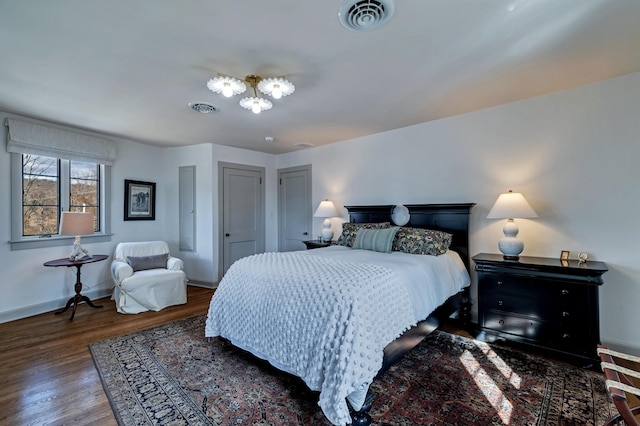 bedroom featuring visible vents, baseboards, and wood finished floors