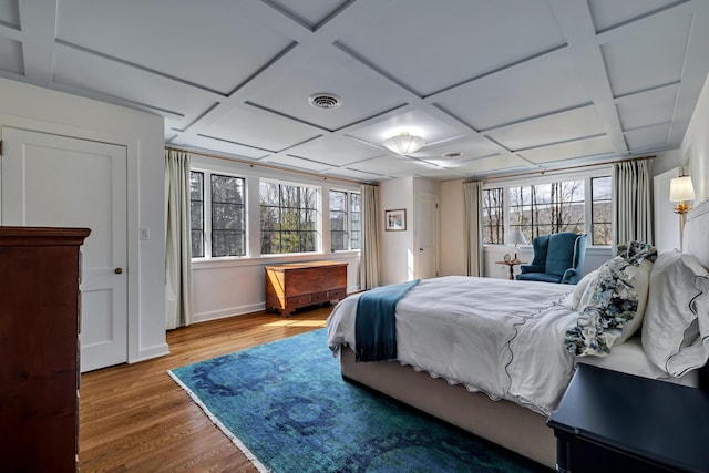 bedroom with visible vents, coffered ceiling, and wood finished floors