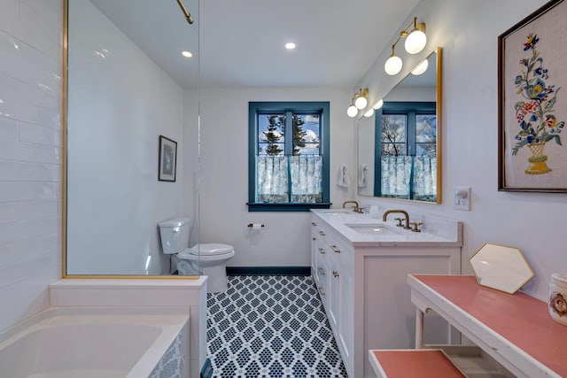 bathroom with toilet, a bathing tub, recessed lighting, baseboards, and vanity