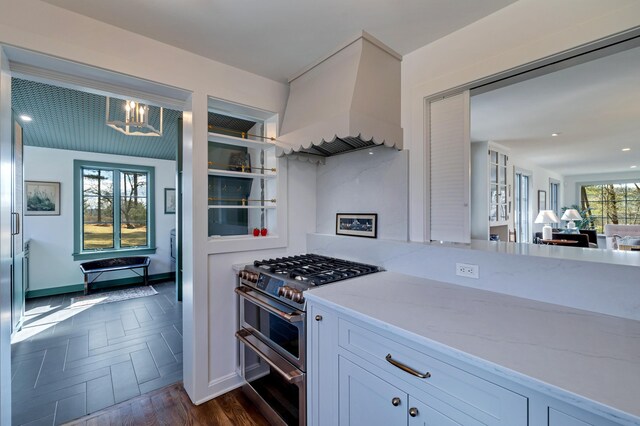 5106 Beattys Cir, Buck Hill Falls, PA 18323 - kitchen featuring range with two ovens, premium range hood, light stone counters, a chandelier, and white cabinets