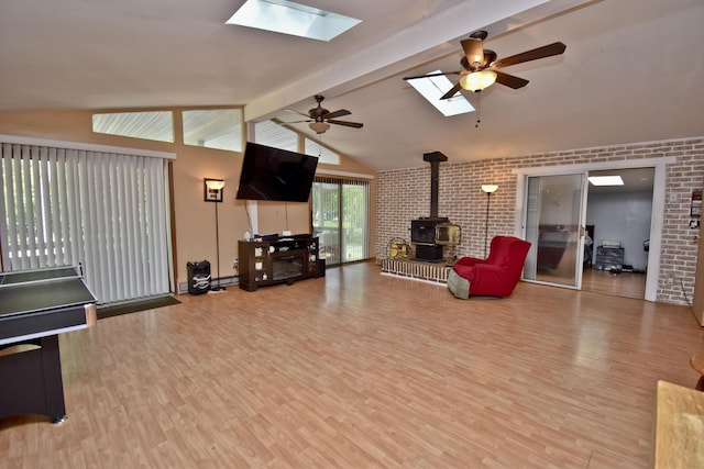 5453 Gingerbread Ln, East Stroudsburg, PA 18302 - living area with a wood stove, a skylight, brick wall, a ceiling fan, and wood finished floors
