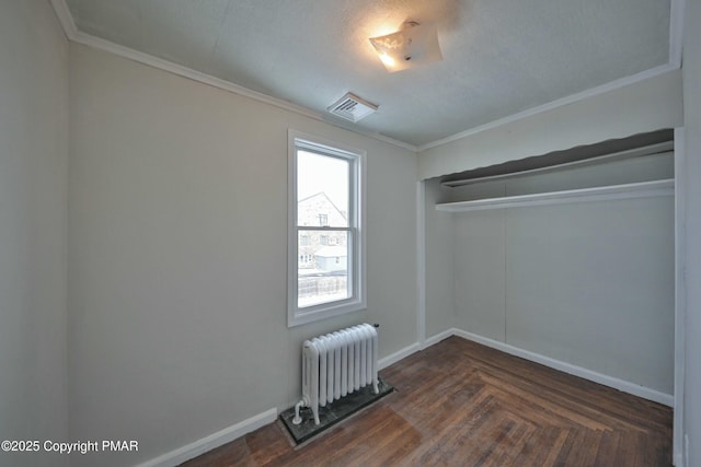 unfurnished bedroom with baseboards, visible vents, crown molding, and radiator heating unit