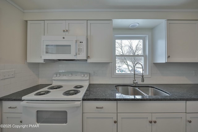 kitchen with white appliances, decorative backsplash, dark stone counters, white cabinetry, and a sink