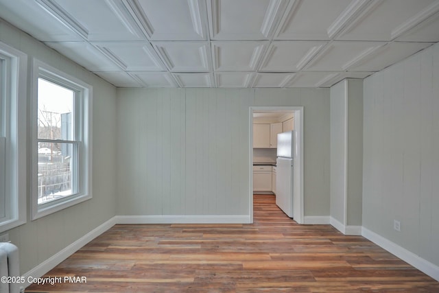 unfurnished room featuring baseboards and wood finished floors