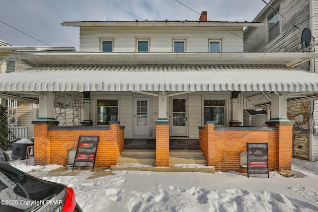 townhome / multi-family property featuring a porch and brick siding