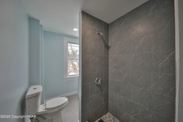 bathroom featuring baseboards, a tile shower, and toilet