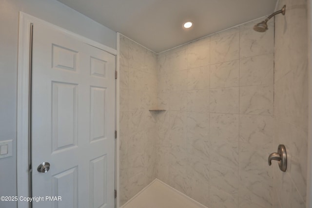 bathroom with tiled shower and recessed lighting