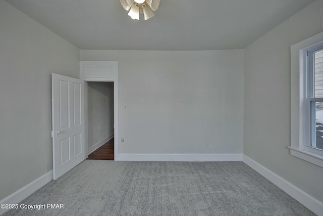 carpeted empty room with baseboards