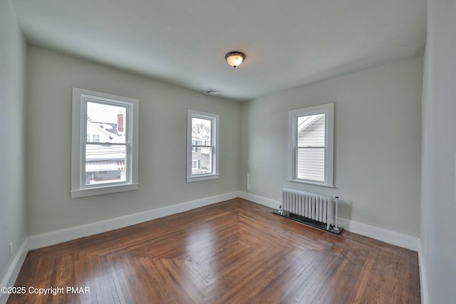 empty room featuring radiator, visible vents, and baseboards