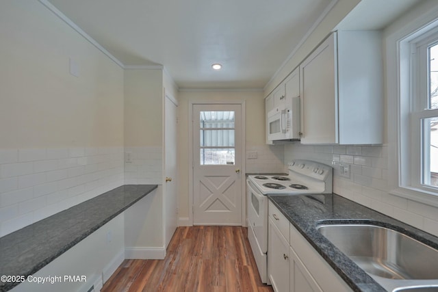 kitchen featuring white appliances, white cabinets, ornamental molding, decorative backsplash, and dark wood-style floors