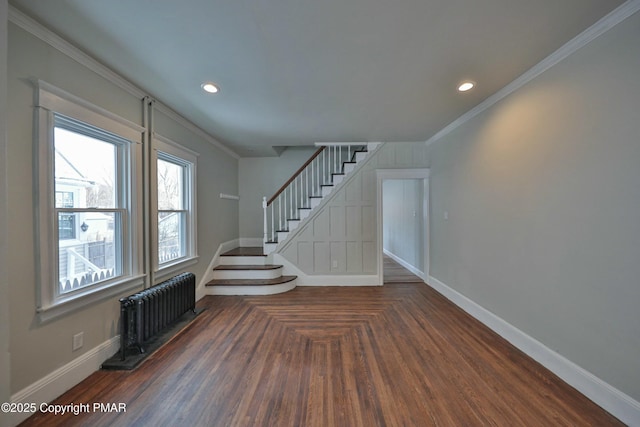 interior space with baseboards, radiator heating unit, wood finished floors, crown molding, and recessed lighting