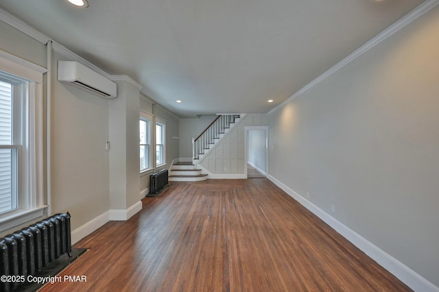 interior space with baseboards, radiator heating unit, wood finished floors, stairs, and a wall mounted AC