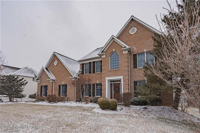 colonial inspired home featuring brick siding