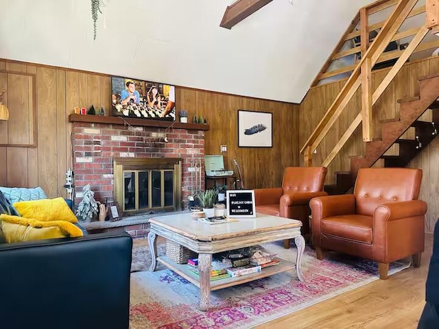 174 Bushkill Dr, Pocono Lake, PA 18347 - living room featuring wooden walls, lofted ceiling, a fireplace, stairs, and wood finished floors
