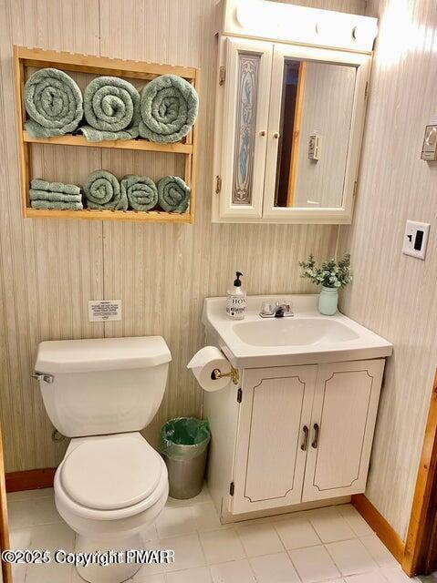 bathroom featuring toilet, baseboards, and vanity