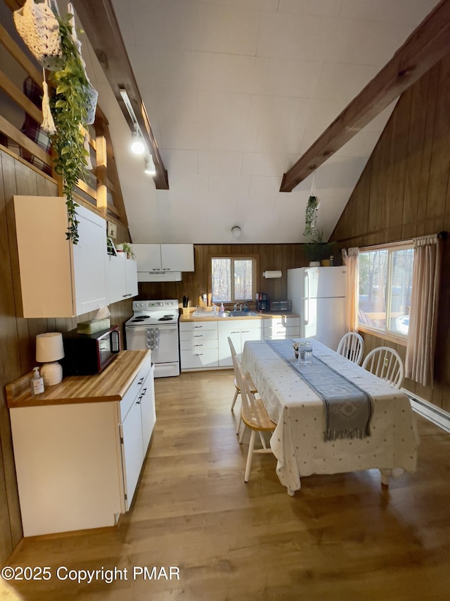 kitchen featuring wooden walls, white appliances, butcher block countertops, white cabinets, and beam ceiling