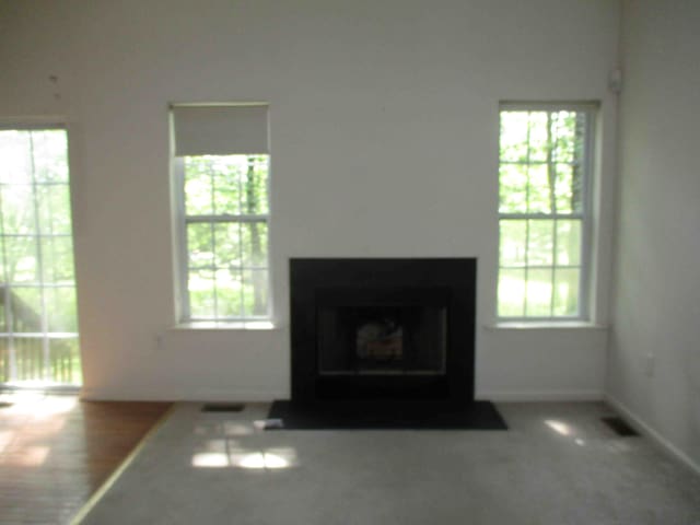 2113 Dorset Ct, Bushkill, PA 18324 - unfurnished living room featuring plenty of natural light and a fireplace with flush hearth