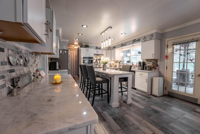 9 Hickory Dr, East Stroudsburg, PA 18301 - kitchen with crown molding, a kitchen bar, backsplash, light stone countertops, and stainless steel appliances