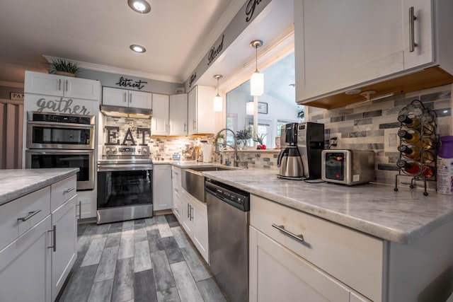 9 Hickory Dr, East Stroudsburg, PA 18301 - kitchen featuring appliances with stainless steel finishes, crown molding, decorative backsplash, light stone counters, and white cabinets