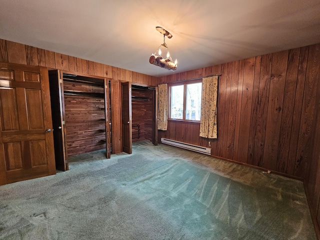 130 Michigana Dr, Pocono Lake, PA 18347 - unfurnished bedroom featuring an inviting chandelier, wood walls, carpet, two closets, and a baseboard heating unit