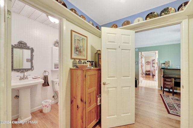 bathroom with a sink, baseboards, toilet, and wood finished floors