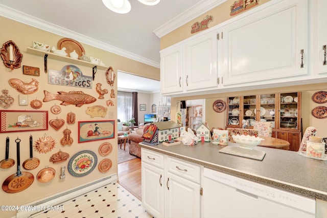 kitchen with light floors, ornamental molding, white dishwasher, and white cabinets