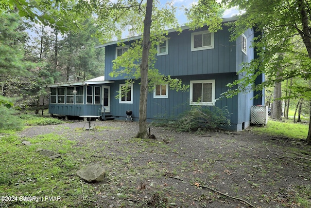 rear view of property with a sunroom